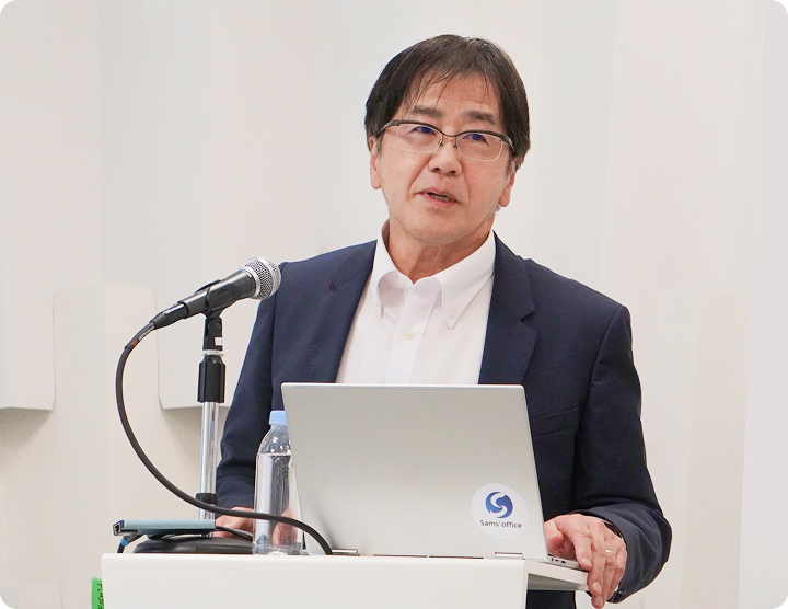 Seigo Kuzumaki speaking at a podium
